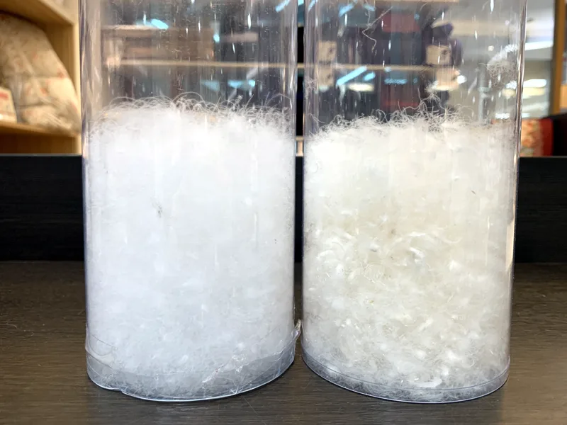 店頭に置いた2本のシリンダーで羽毛のかさ高と色を見比べた様子