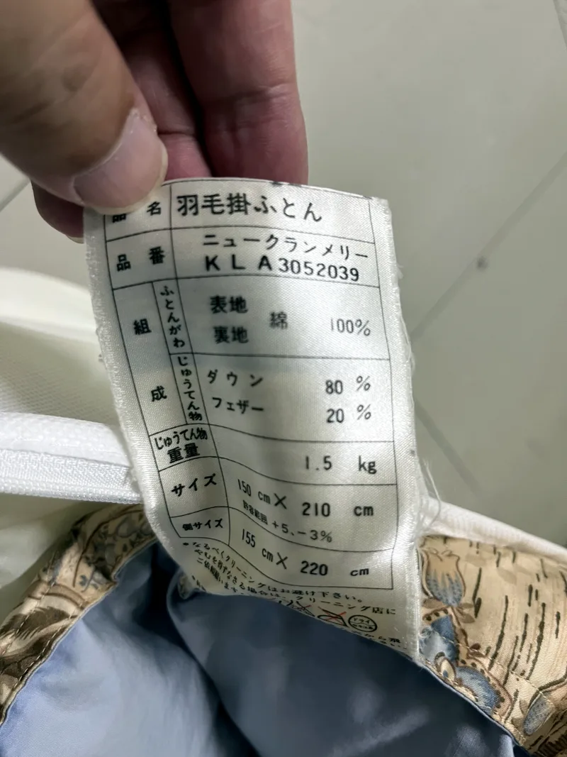 羽毛ふとんの品質表示タグ。ダウン率・充填量・サイズが記載されている